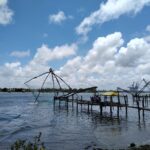 Kerala Traditional Chinese fishing nets silhouetted against a clear blue sky in Kerala.